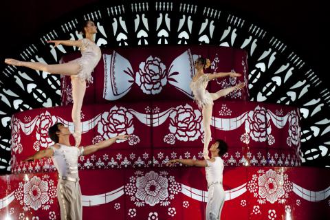 acrobats in front of elaborate red and white backdrop